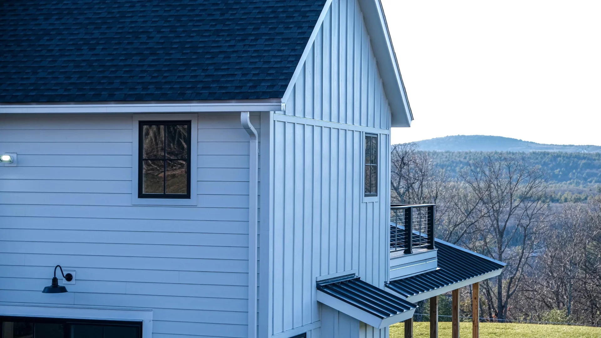 Home with a shingle roof and metal porch roof in Rochester, NY